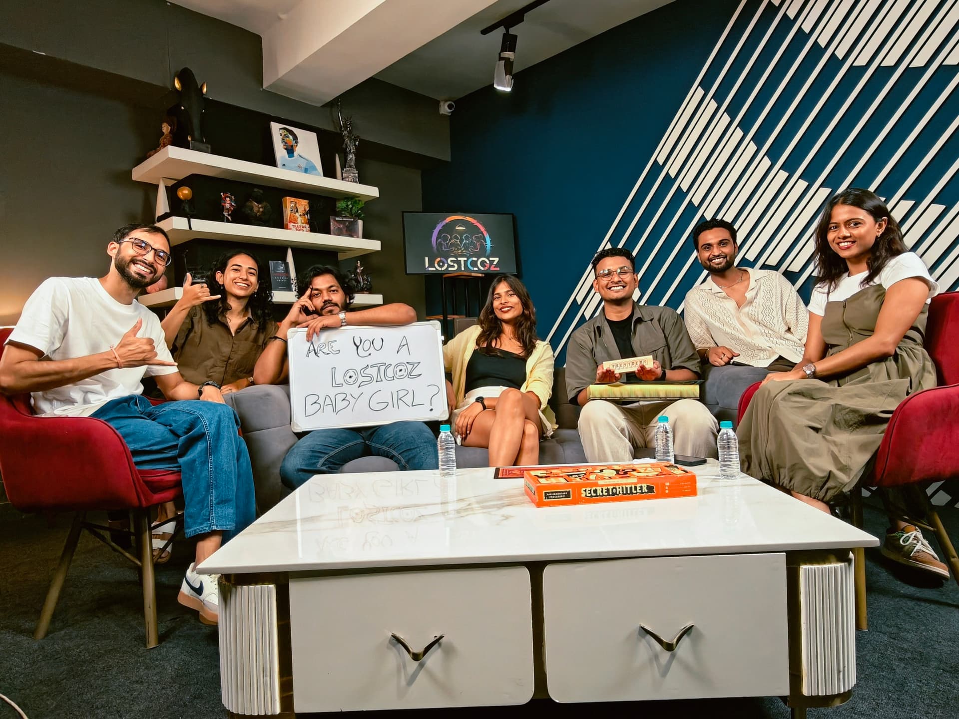 A Lostcoz game night: seven people around a table mid-game